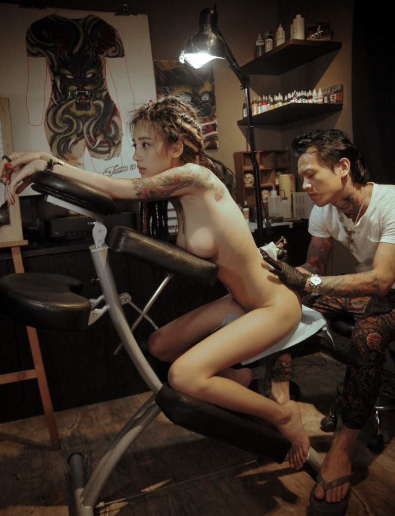 Beautiful nude asian girl gets tatoo